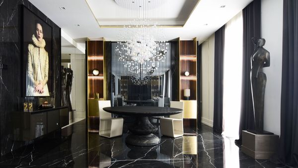 Dining room with sculptural chandelier and black marble